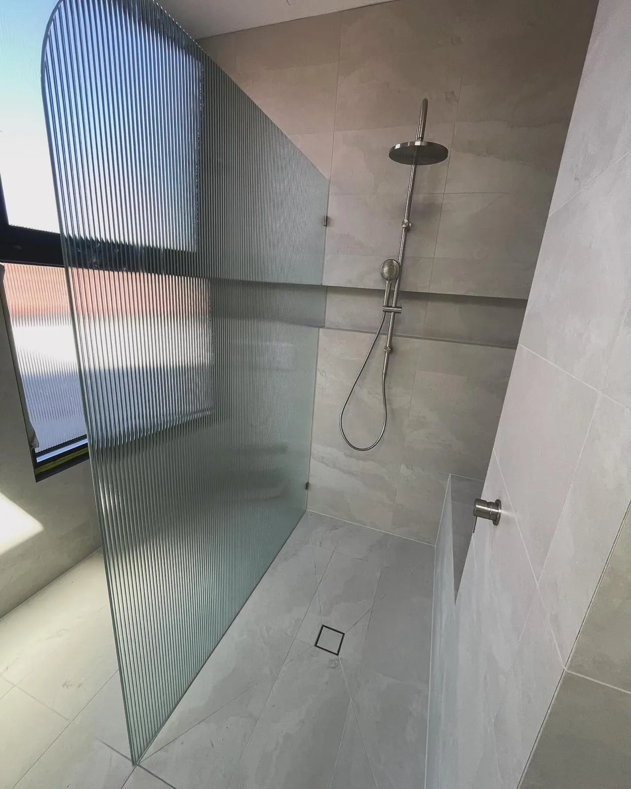 Reeded frameless shower screen in a Hawthorn bathroom