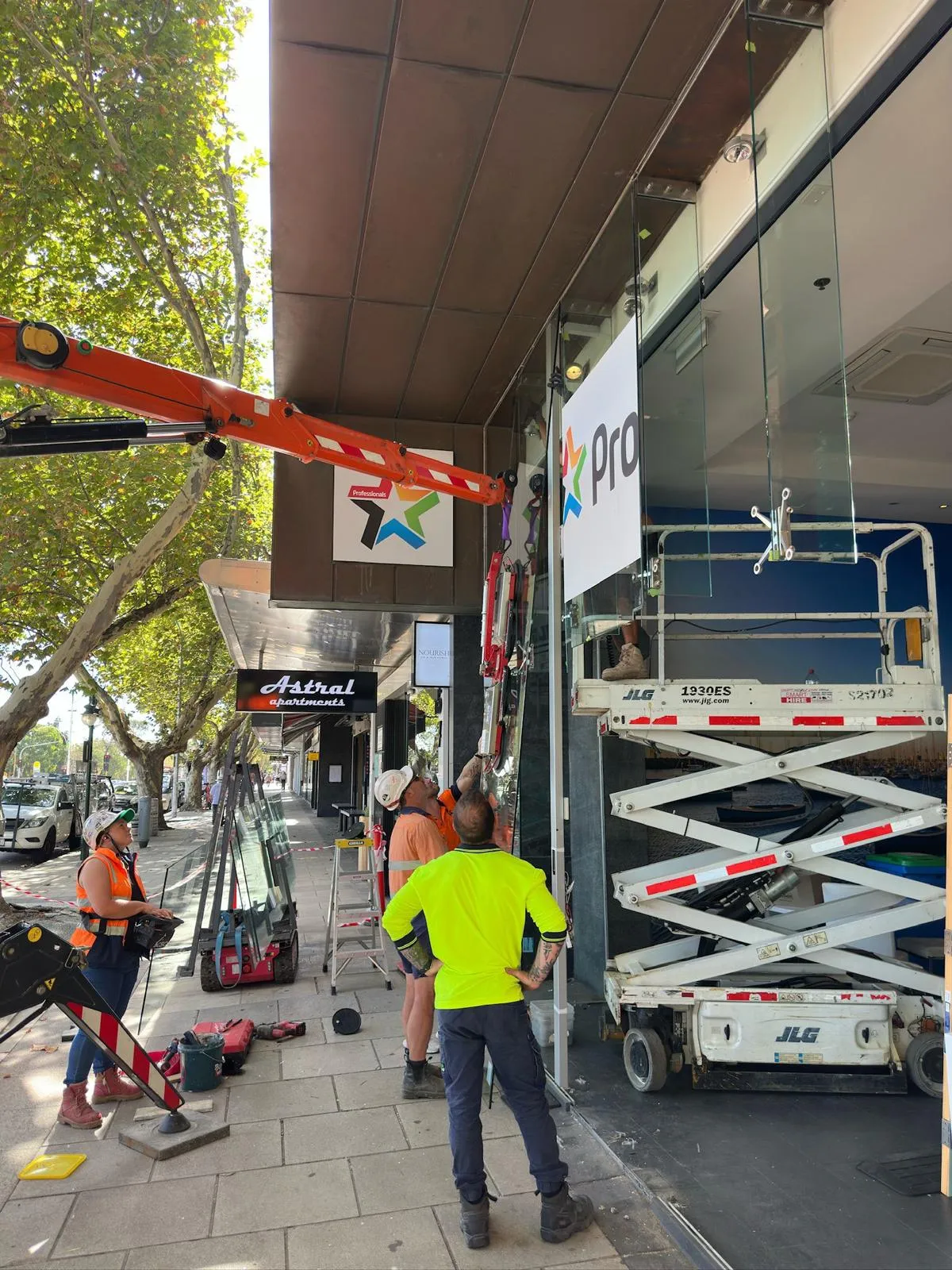 The Maison Glass & Aluminium team installing a glass façade panel on site